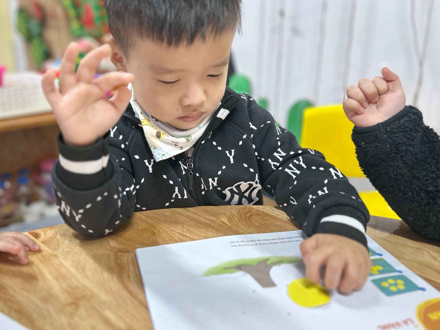 A child sitting at a table with his hands up

AI-generated content may be incorrect.