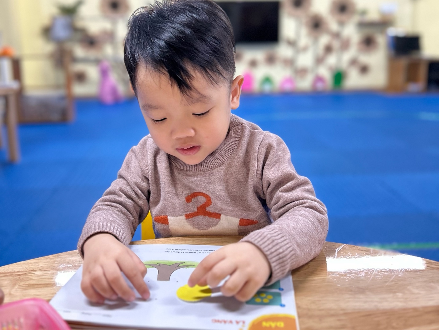 A child sitting at a table with a book

AI-generated content may be incorrect.