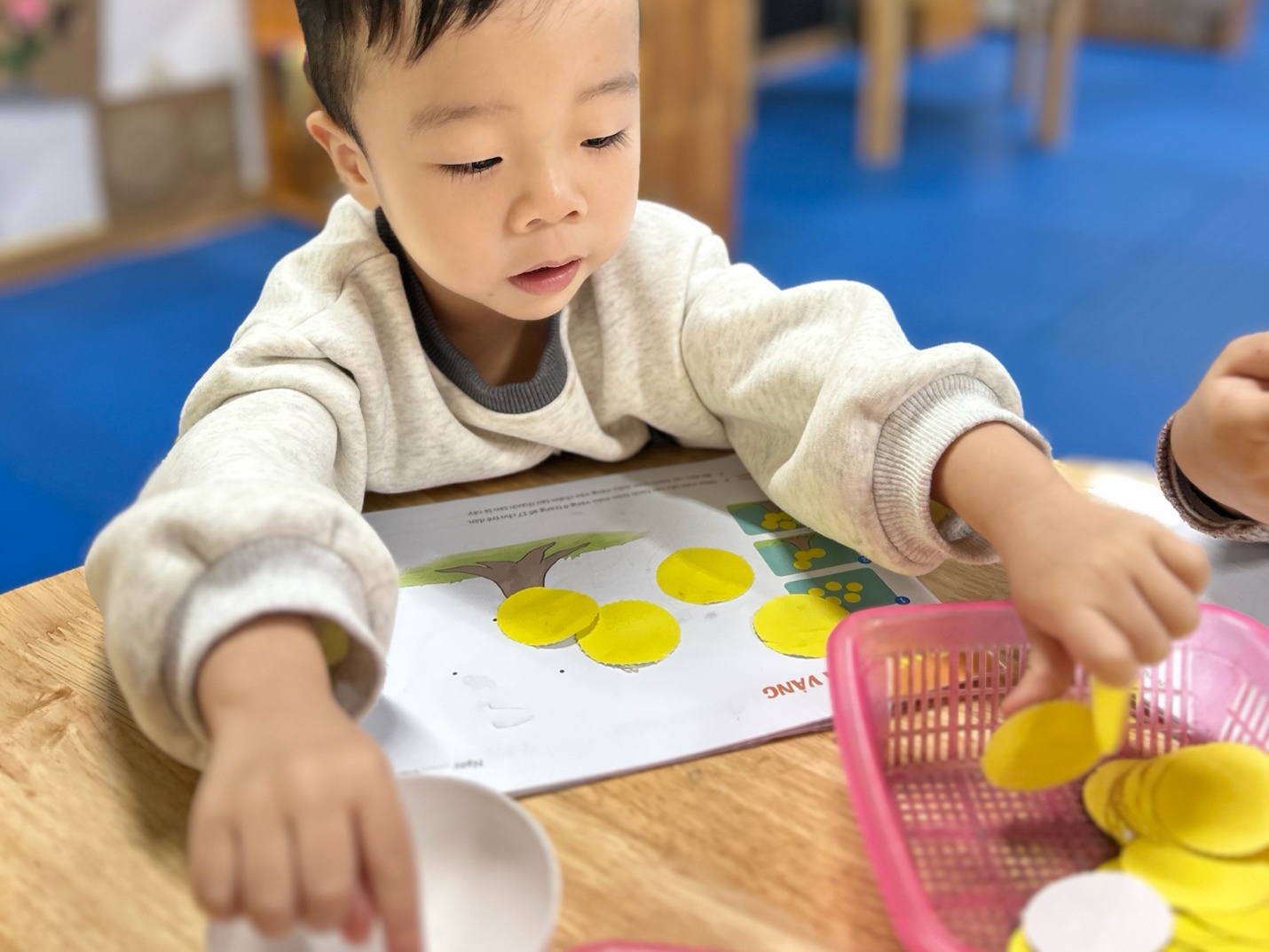 A child playing with yellow circles

AI-generated content may be incorrect.