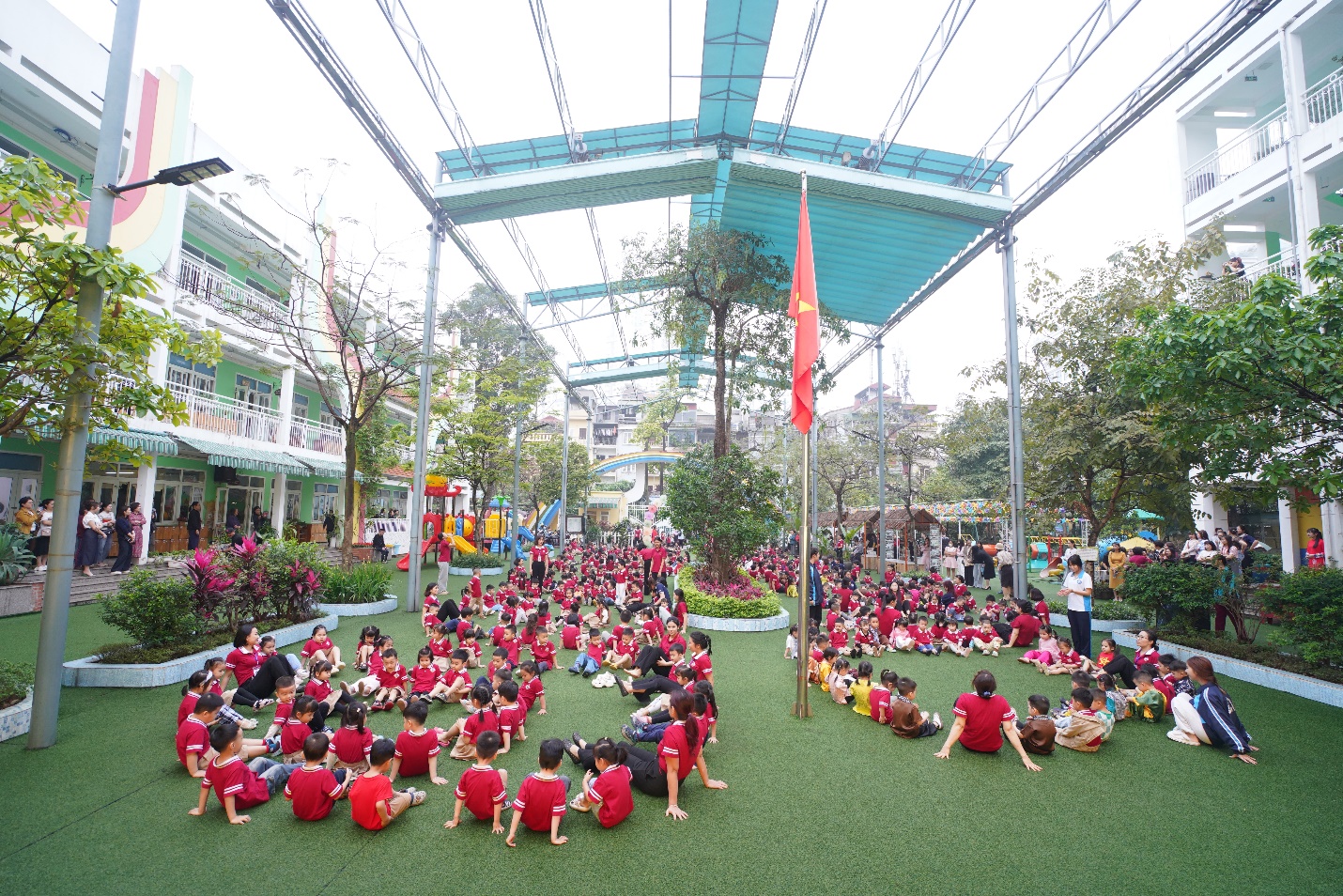 A group of children in red shirts sitting on grass

AI-generated content may be incorrect.