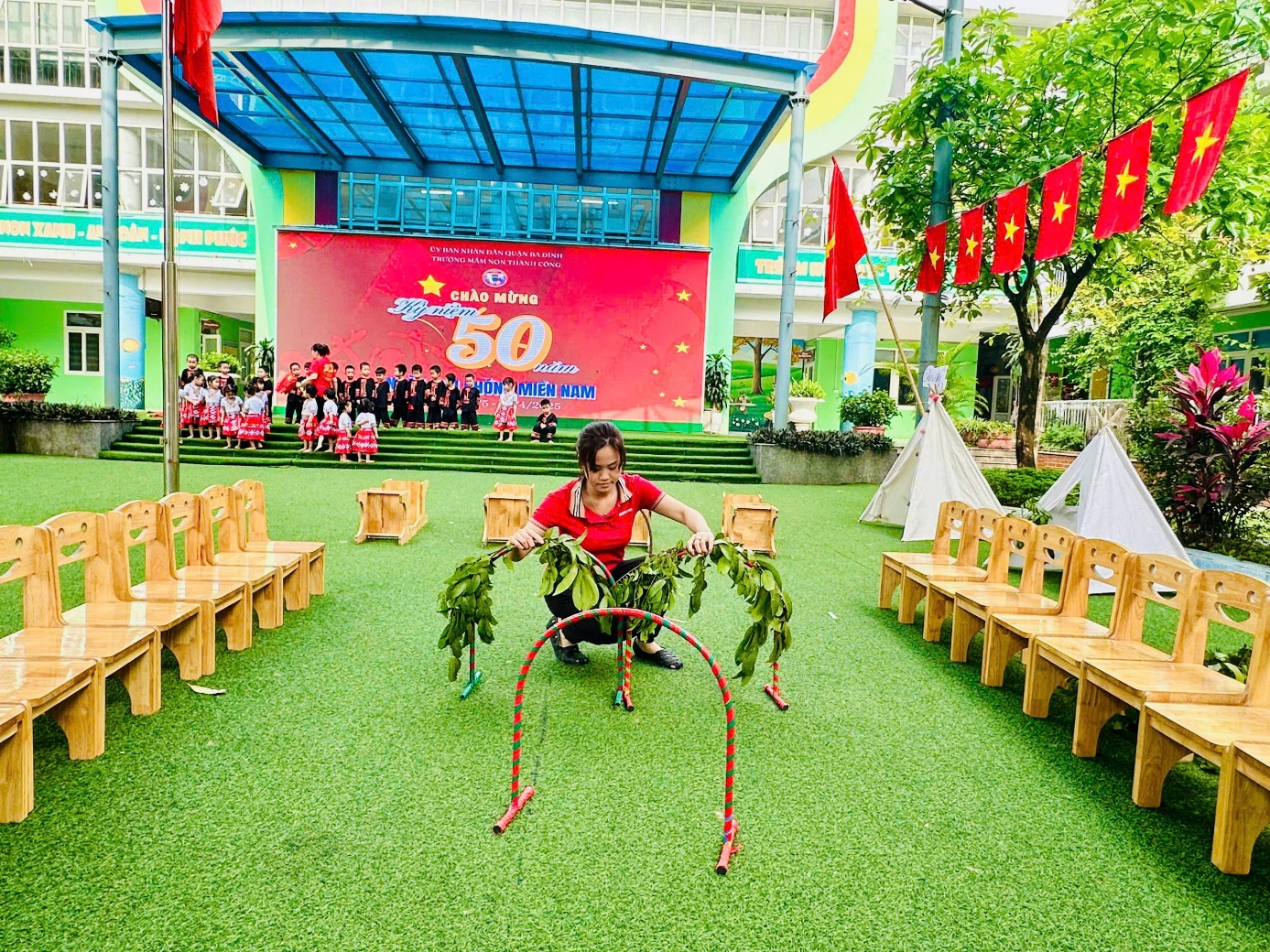 A person in a red shirt squatting on a green field with chairs and flags

AI-generated content may be incorrect.