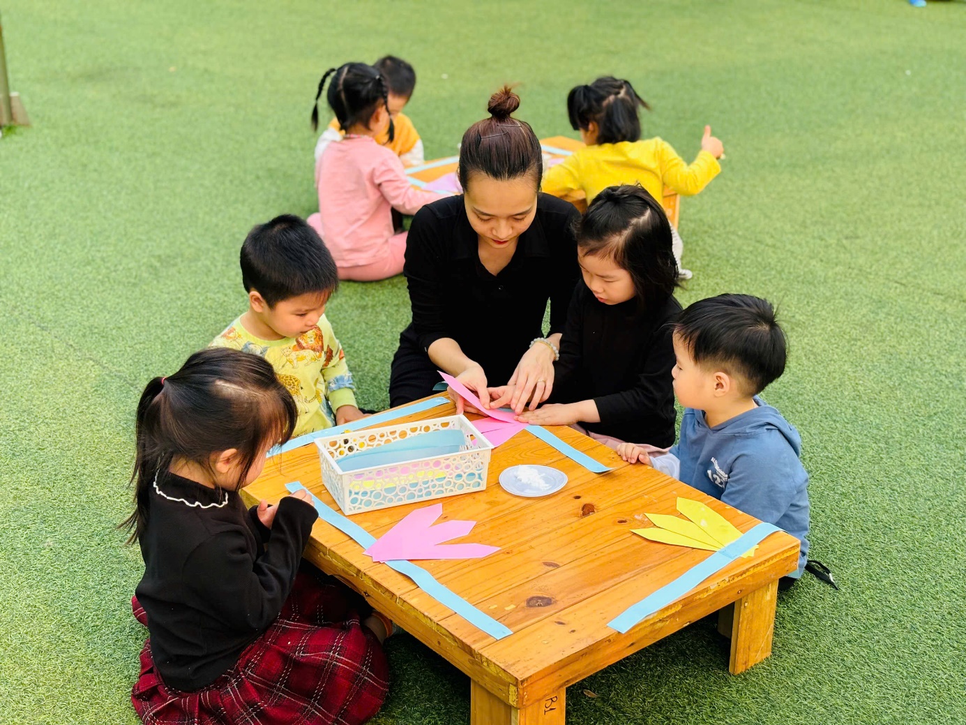 A group of children sitting around a table

AI-generated content may be incorrect.
